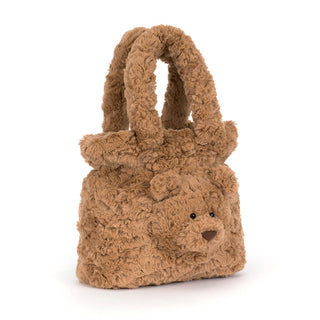 A small teddy bear-shaped handbag made of textured, curly brown faux fur, featuring a cute embroidered face and dual top handles, set against a plain white background.