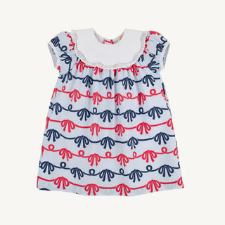 Children's dress with red and blue pattern on a pale blue background
