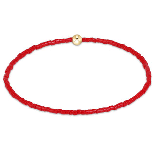 small red bead bracelet with single gold bead