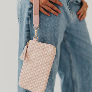 blush and cream leather wristlet bag in a woven pattern with gold hardware and blush tassel and wrist strap