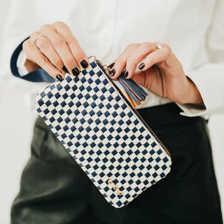 navy and cream leather wristlet bag in a woven pattern with gold zipper and navy tassle