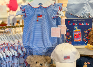 Children's clothing and toys with American flag design in a store setting