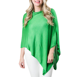 A woman wearing a green bamboo knit poncho with a 3/4 length sleeve and a high neck.